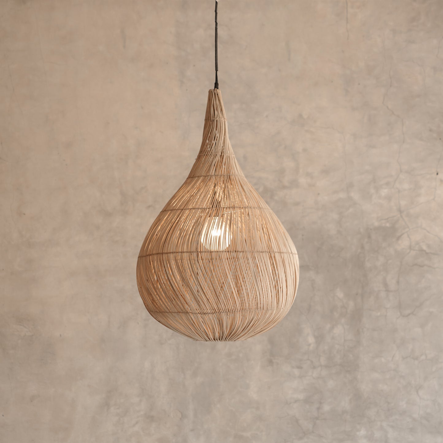 Woven pendant light hanging against a beige wall