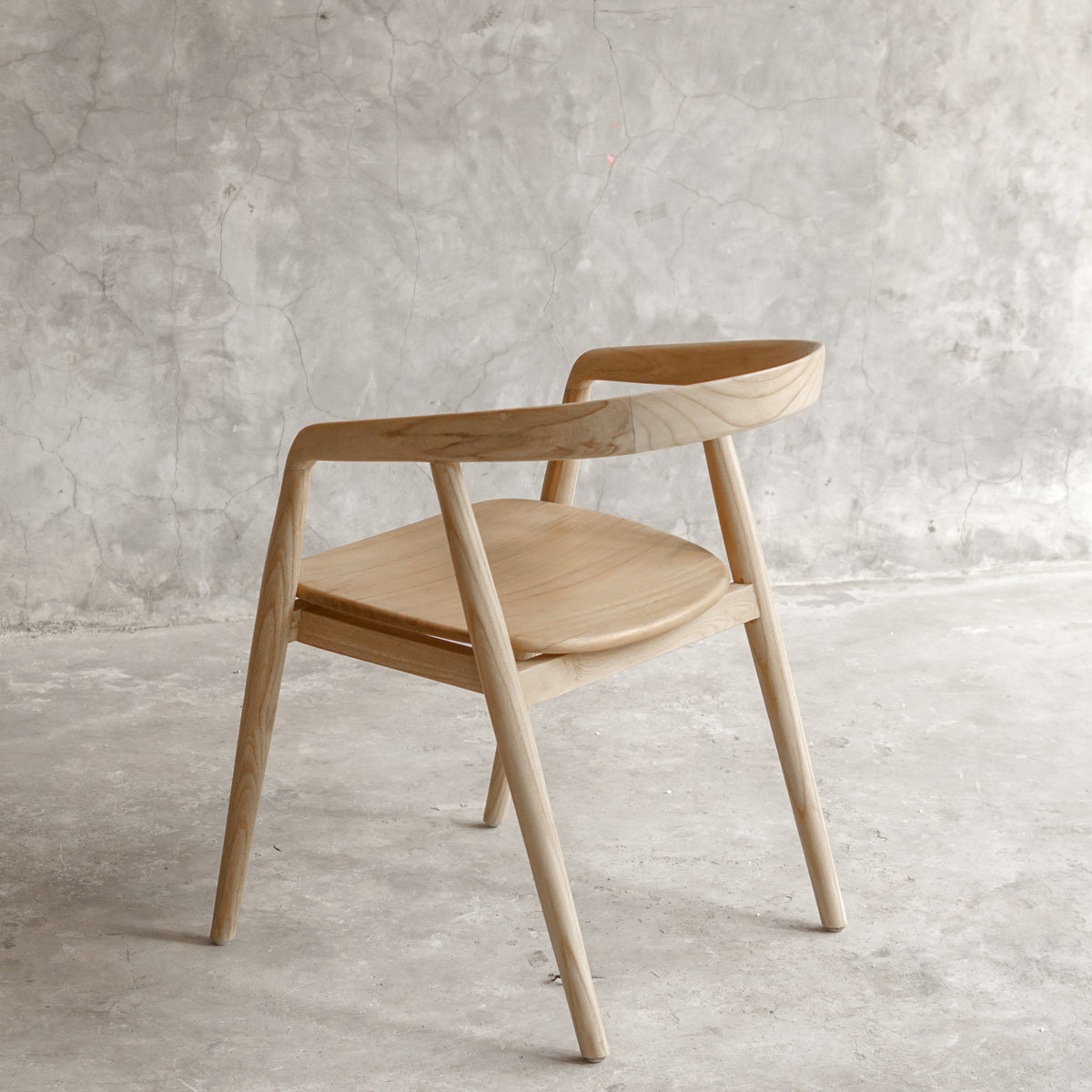 Wooden chair in a minimalistic room with concrete floor and wall