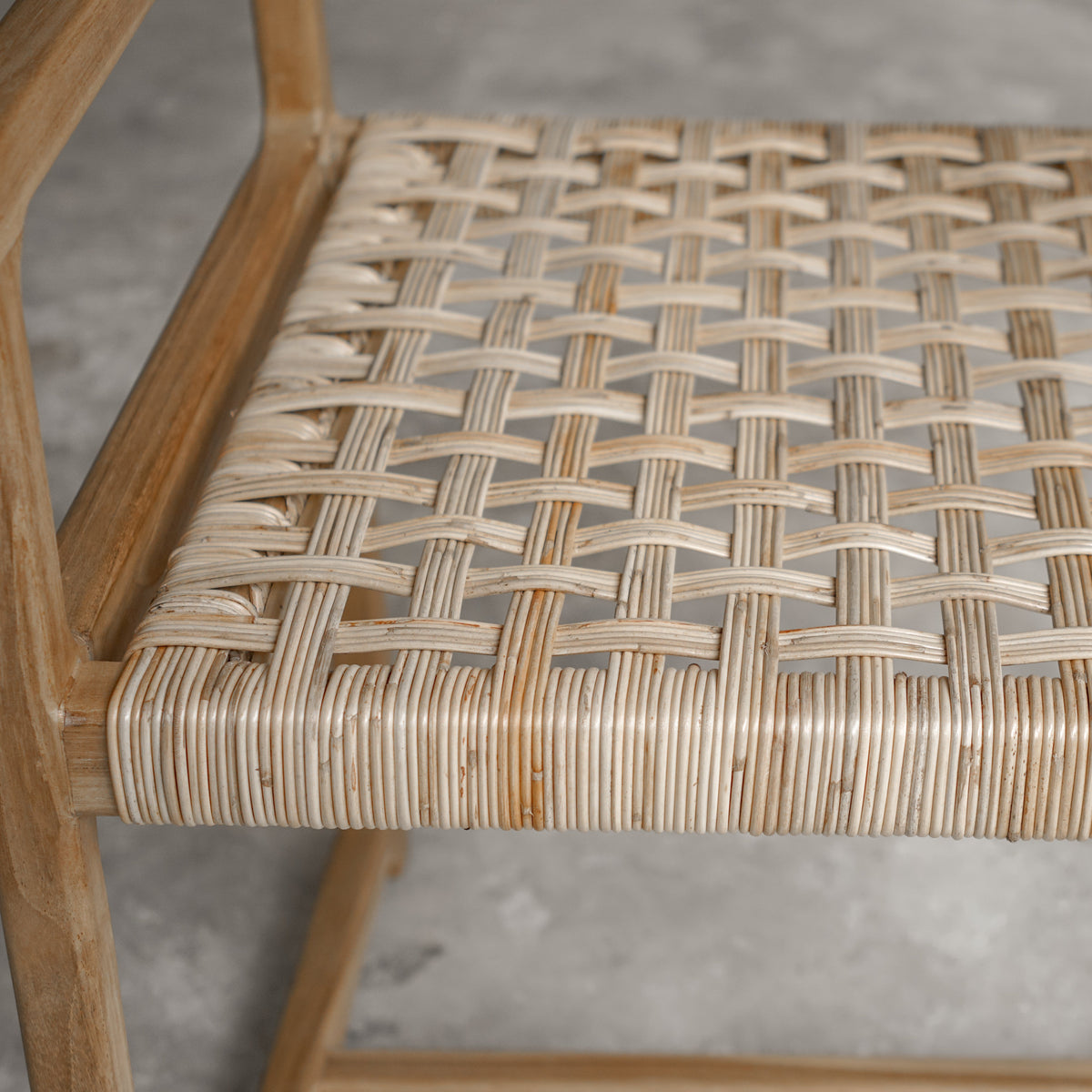 Wooden chair with woven seat on a concrete floor