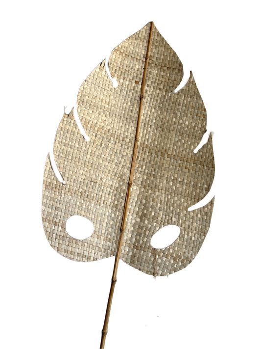 A handmade decorative palm leaf made from natural plant fibers, mounted on a bamboo stem.