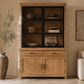 Wooden cabinet with glass doors and shelves in a living room setting.