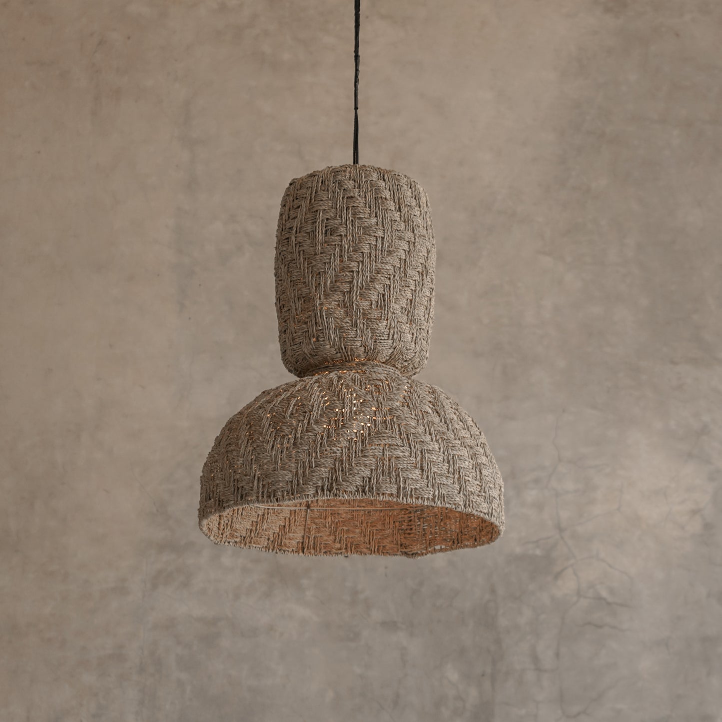 Textured pendant light hanging against a beige wall