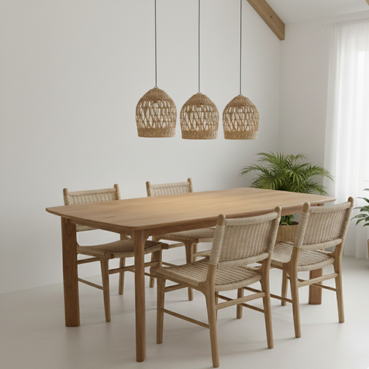 Dining area with wooden table and chairs under wicker pendant lights.
