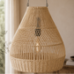 Woven rattan pendant light hanging indoors with a neutral background