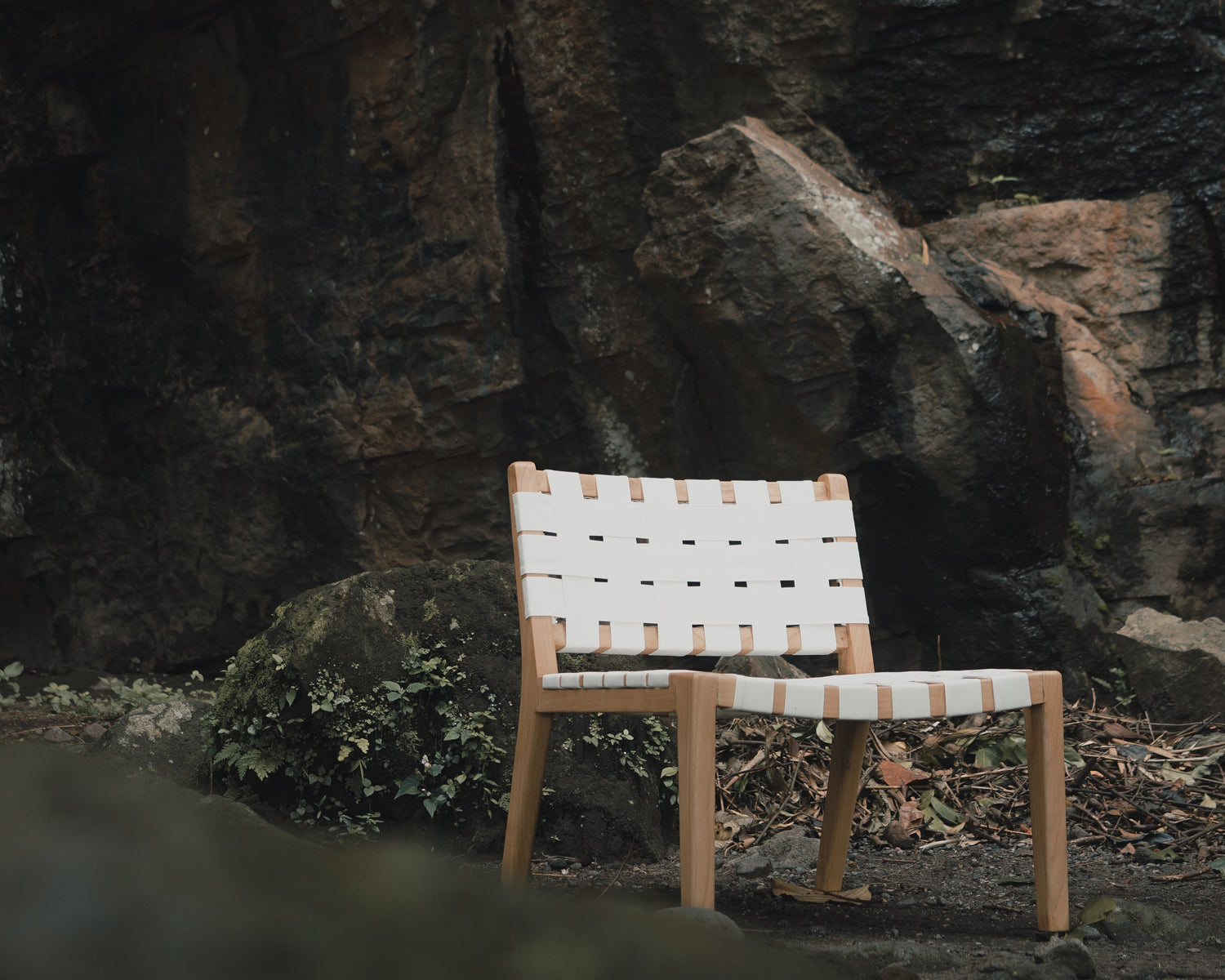 Chair with a striped backrest against a rocky wall