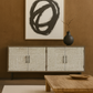 Modern interior with a textured wall, abstract art, and wooden furniture.