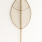 Decorative leaf-shaped wall art made of gold wire on a white background