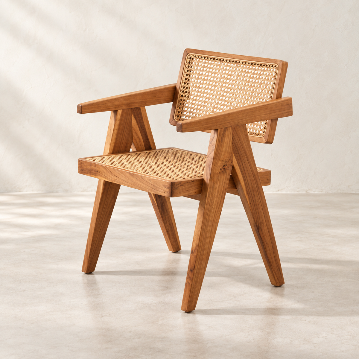 A mid-century modern wooden armchair with a natural cane backrest and seat, shown on a light concrete floor against a neutral beige wall.