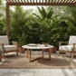 Outdoor patio with wooden furniture, table, and plants in a tropical setting