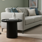 Gray sofa in a living room with a black side table and decorative items.
