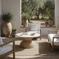 Outdoor patio with wooden furniture, wicker table, and potted plants.