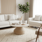 Modern living room with white sofas, a round coffee table, and decorative elements.