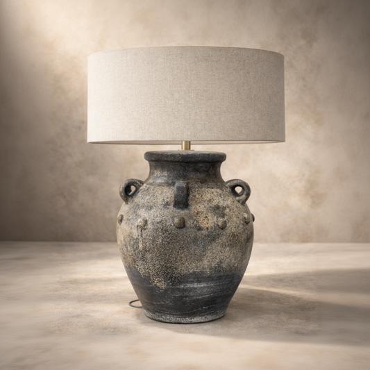 Table lamp with textured base and beige lampshade on a neutral background