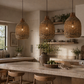 Kitchen with wicker pendant lights, wooden stools, and a vase on the counter.
